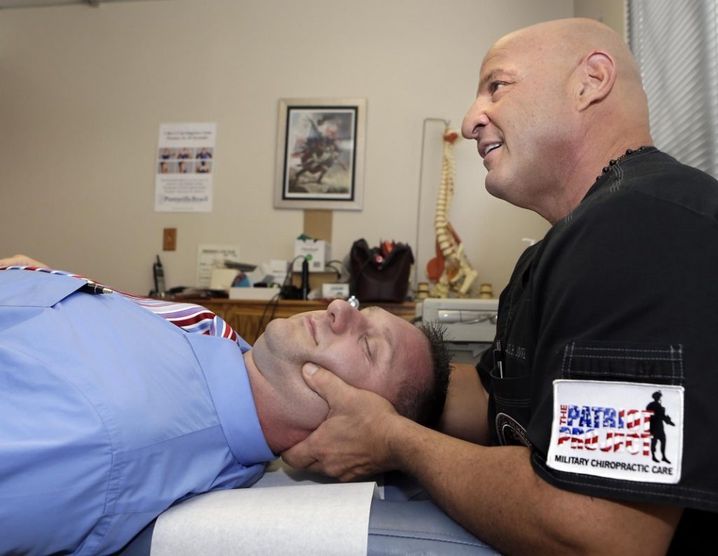 blog picture of chiropractor working on military service member