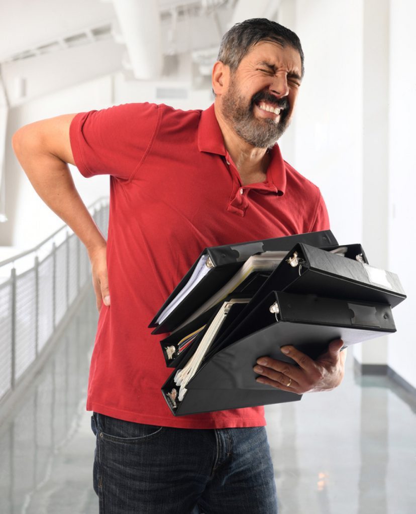 stock photo empresario hispano experimentando dolor de espalda mientras lleva carpetas