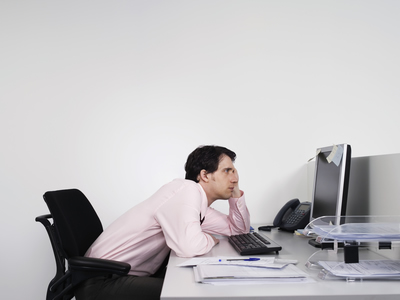 working man sitting at desk slouched