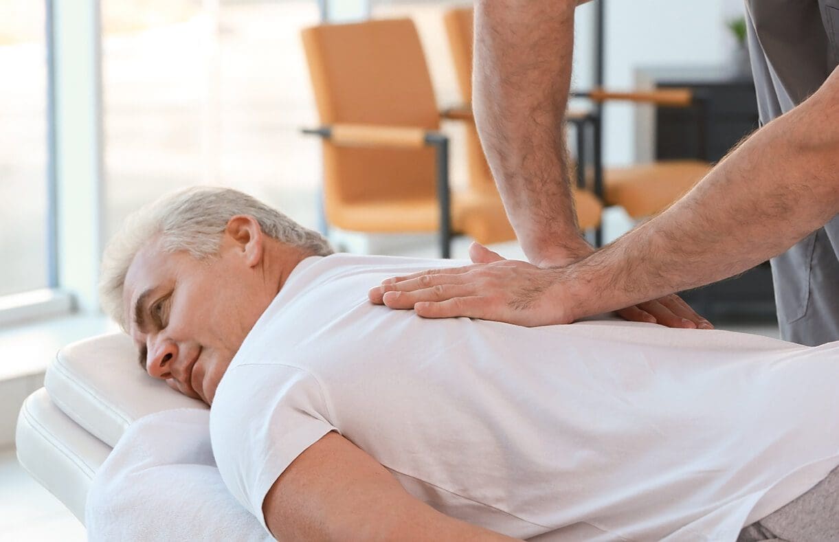Image of an olden man receiving massage therapy to improve their migraine | El Paso, TX Chiropractor